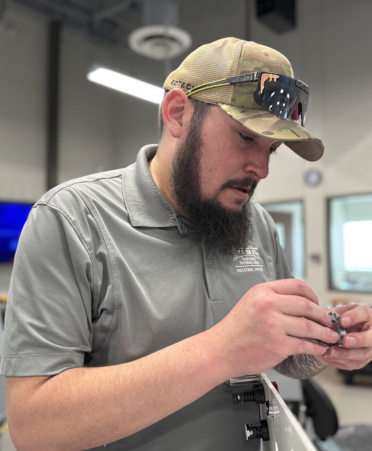 man in grey shirt working on control panel