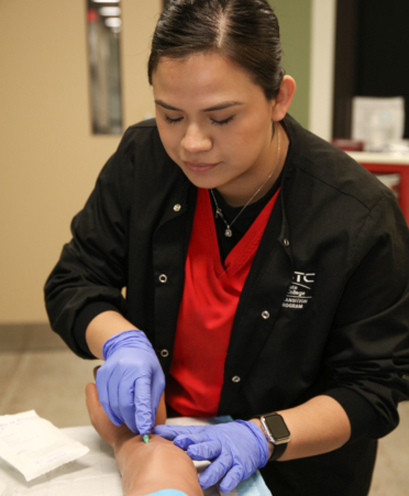 Nancy Roblero, a LVN to RN Transition Nursing student at Texas State Technical College’s Harlingen campus, inserts an IV into a manikin arm during a lab session.