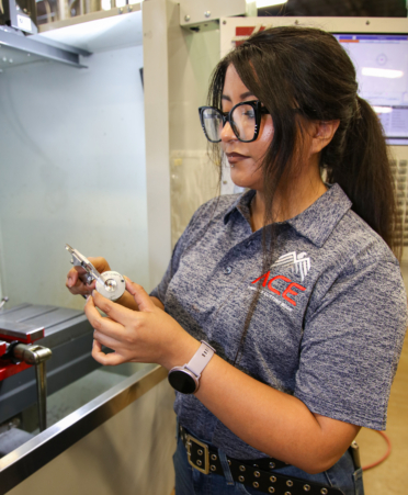 Laura Herrera, a recent Precision Machining graduate, measures steel during the America’s Cutting-Edge (ACE) computer numerical control (CNC) machining boot camp hosted at Texas State Technical College’s Harlingen campus.