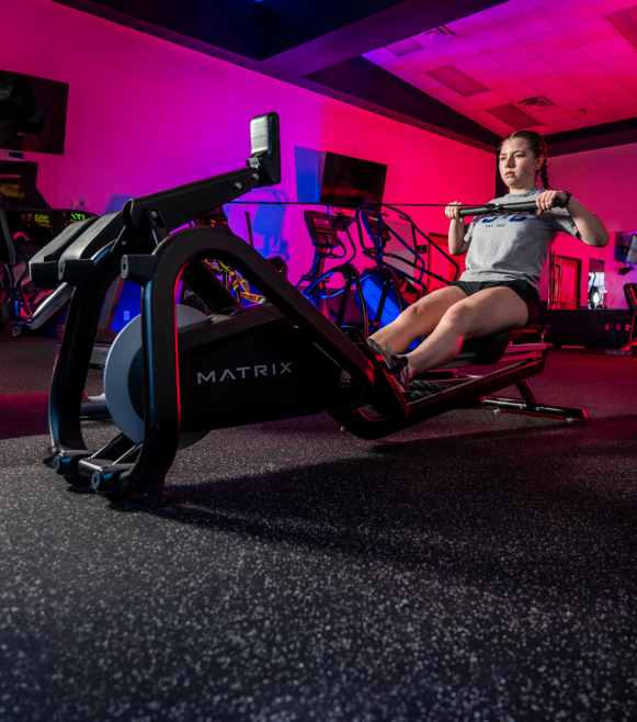 student using exercise rower in rec center