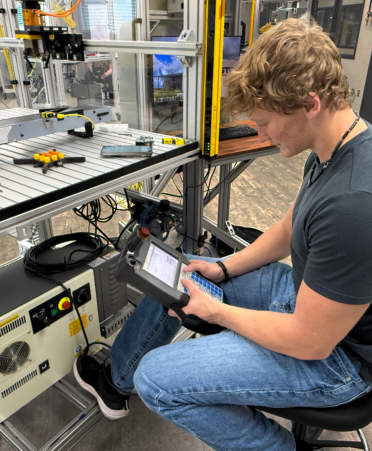 Photo caption: Austin Henson, an Automation and Robotics student at Texas State Technical College, operates a robot teaching pendant at TSTC’s Waco campus. TSTC is expanding its Associate of Applied Science degree program in Advanced Manufacturing - Automation and Robotics to the Williamson County campus in Hutto this fall. (Photo courtesy of TSTC)