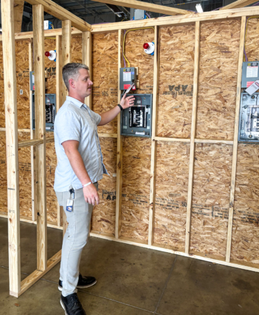Shawn McNeil, Electrical Construction program team lead at Texas State Technical College’s Fort Bend County campus, explains the electrical panels and equipment students will use during lab sessions this fall.