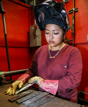 2R7A0379-2 Perla Contreras, a Welding student at Texas State Technical College’s Harlingen campus, prepares metal plates on a welding table during a lab session.
