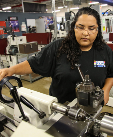 Teresa Lopez, a Precision Machining student at Texas State Technical College’s Harlingen campus, uses a high-speed lathe to cut steel during a lab session.