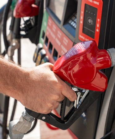 Close up of male hand holding fuel pump nozzle at gas station, c gas pump